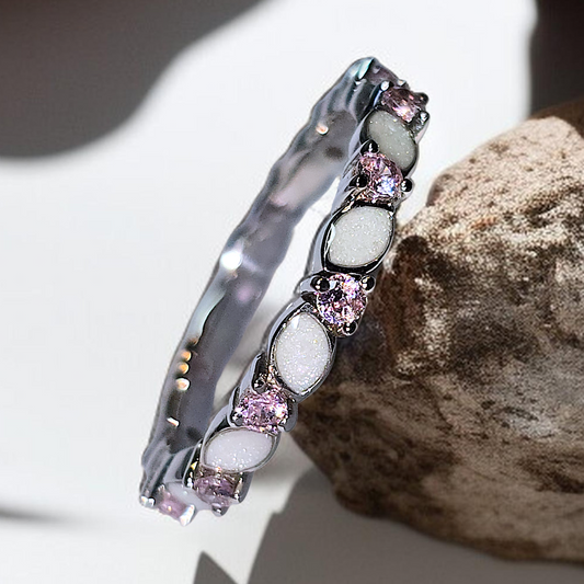 Sterling silver breastmilk or ashes keepsake ring featuring marquise white inclusion stones alternating with sparkling pink birthstones.